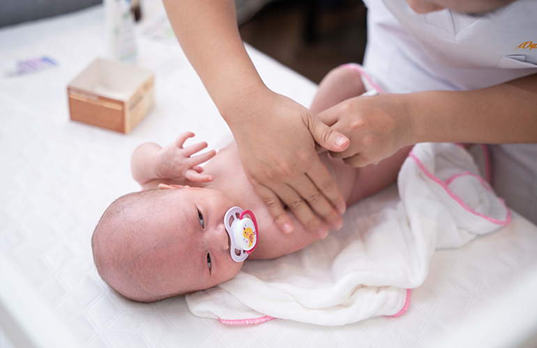 Điều dưỡng viên Vạn Phúc Care thực hiện massage cho trẻ sơ sinh