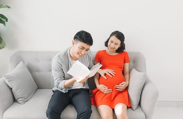 Bố mẹ cùng nhau đọc truyện cho thai nhi để thực hiện thai giáo.