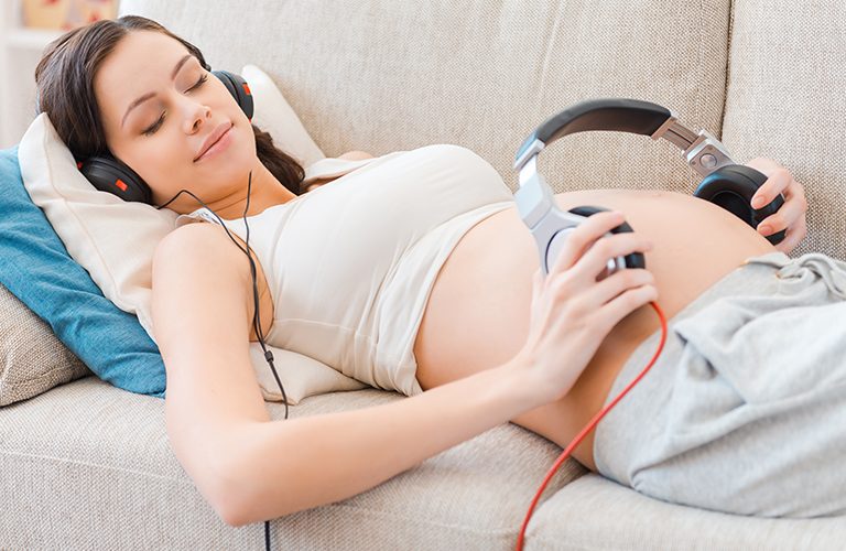 Mẹ bầu nằm nghe nhạc cùng thai nhi.