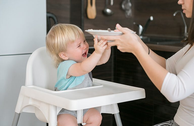 Trẻ từ chối ăn, dùng tay đẩy thức ăn khi được mẹ bón.
