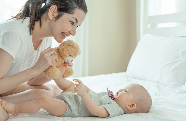 Mẹ dỗ dành và kiên nhẫn chơi gấu bông cùng bé.