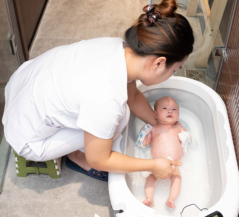 Điều dưỡng viên của Vạn Phúc Care tắm cho trẻ sơ sinh.