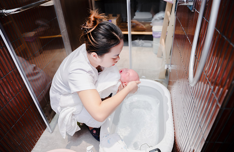 Điều dưỡng viên Vạn Phúc Care tắm bé.