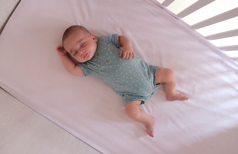 Bé trai ngủ ngon trong cũi