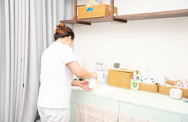 Bảo mẫu pha sữa cho bé.