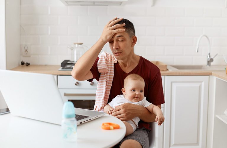 Bố vừa bế con trên tay vừa làm việc