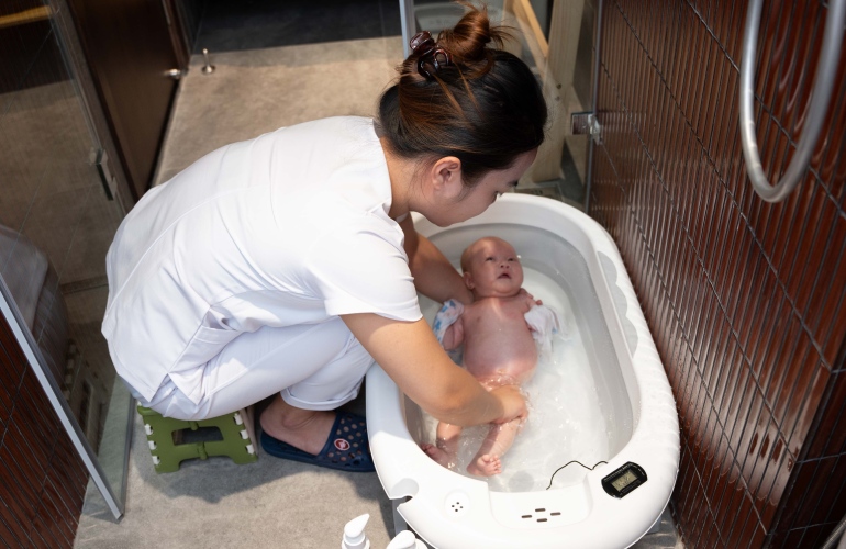 Điều dưỡng viên Vạn Phúc Care tắm cho bé..