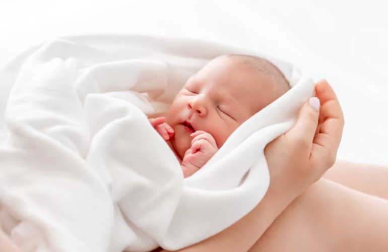 Trẻ sơ sinh ngủ trên tay mẹ