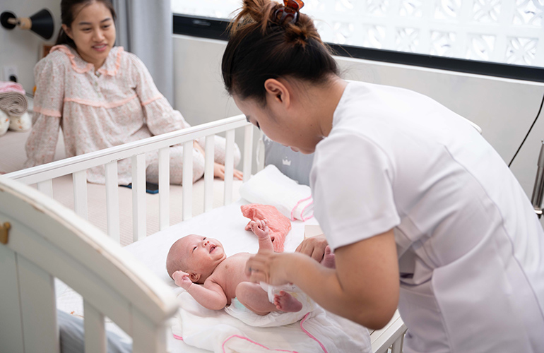 Điều dưỡng viên Vạn Phúc Care thực hiện massage cho trẻ sơ sinh